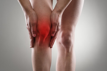 Tendon problems on woman's leg indicated with red spot. - 73674722