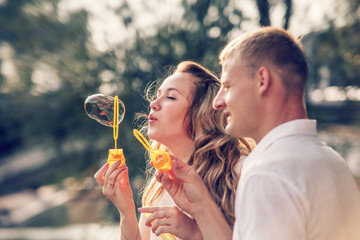 Fototapeta premium Young couple funny plaing with Soap bubbles