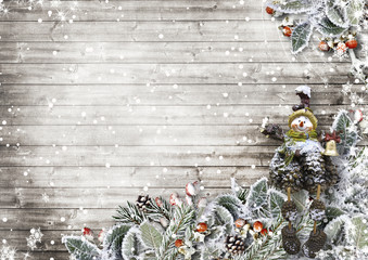 Christmas card on a wooden board with beautiful snowy leaves
