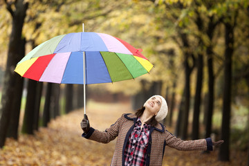 Girl with multicolored umbrella checking if its raining