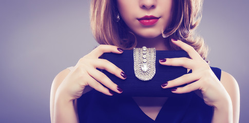 Beautiful young woman with a black clutch in hand.
