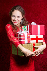 Happy girl in red dress with gift box.
