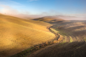 Beautiful mists in rolling fields in Tuscany, Italy