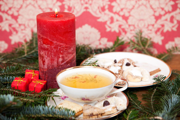 Weihnachtstee mit Keksen, Kerze, Tannenzweige