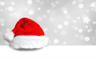 Weihnachtsmütze auf weißem Plakat mit schönem Bokeh