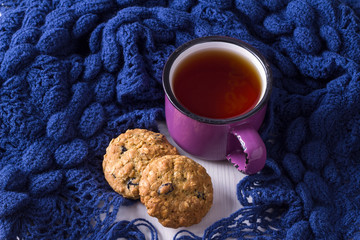 Cup of hot tea, oatmeal cookies and warm scarf. Winter motifs