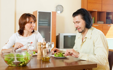 couple eating vegetables and herbs in the home