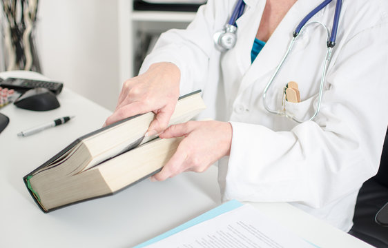 Female doctor opening a medical book