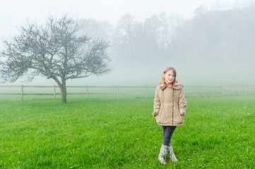 Outdoor portrait of a cute little girl on a foggy day © annanahabed