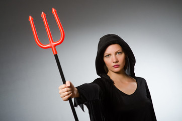 Halloween concept with woman holding pitchfork