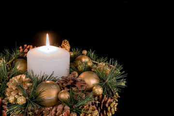 Christmas decoration with a white candle and pine apples