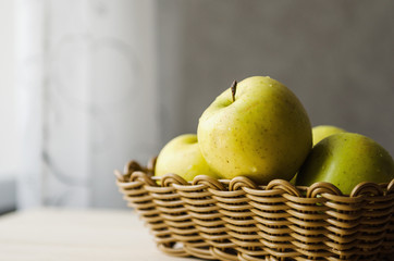 yellow wet fresh apples in a wicker basket