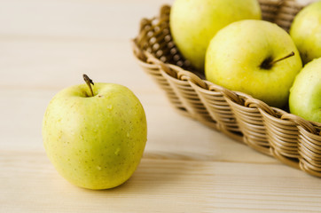 yellow wet fresh apples in a wicker basket