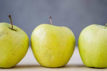 fresh yellow apples on a wooden table