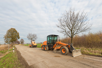 Strassenbau - Ein Grader und ein Walzenzug auf einer Strasse