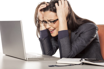 shocked young businesswoman looking in her laptop