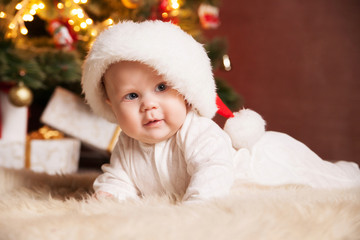 Obraz na płótnie Canvas Happy baby wearing Santa hat over christmas tree