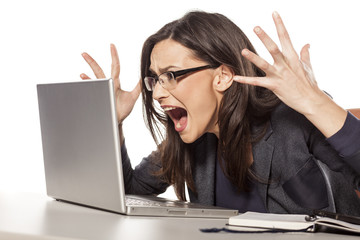 angry young businesswoman shouting at her laptop