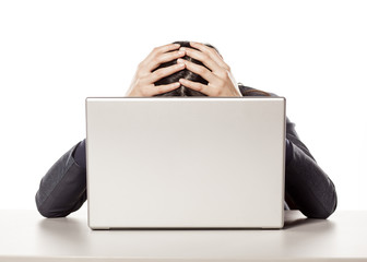 young unhappy businesswoman crying behind her laptop