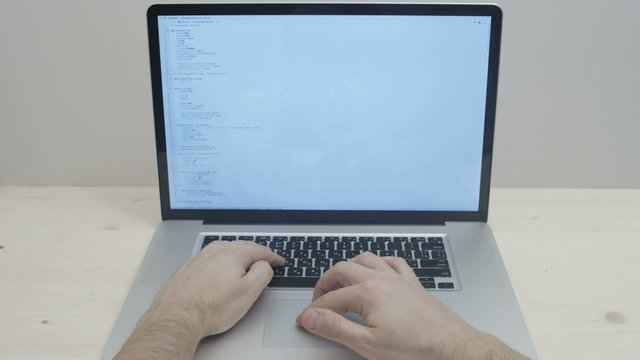 hands typing css code on notebook