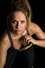 woman in black sports bra lean forward one hand