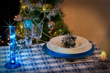 table set for christmas dinner with decoration blue and silver
