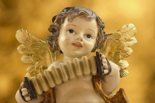 Angel with accordion on golden background
