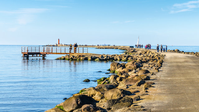 People have walk on promenade at Mangalsala, Riga