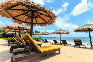 Sun umbrella and sun loungers stand at the beach in Phuket, Thai