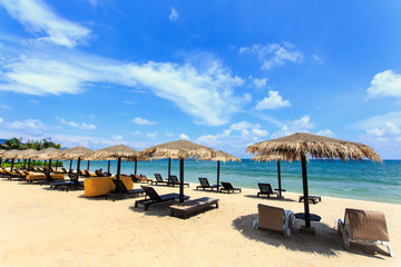 Sun umbrella and sun loungers stand at the beach in Phuket, Thai