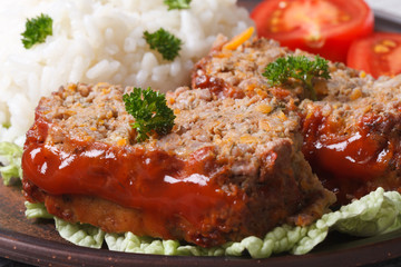 meatloaf with rice and vegetables on a plate macro