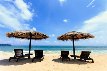 Sun umbrella and sun loungers stand at the beach in Phuket, Thai