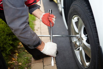 Obraz premium Car mechanic changing tire.