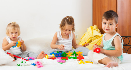  kids playing on  white bed