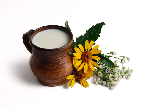 Milk in brown ceramic bowl, summer flowers