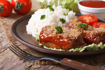 pieces of meatloaf and rice on a plate close-up, horizontal