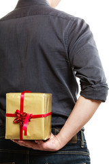 Holiday. Man hiding surprise gift box behind back