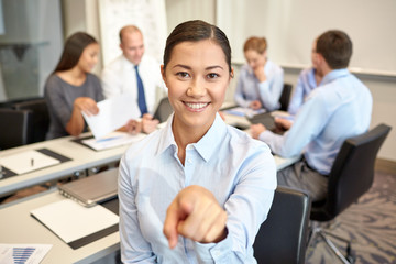 group of smiling businesspeople meeting in office