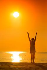 silhouette of woman practicing yoga on the sunset