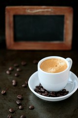 Coffee cup and coffee beans with blank chalk board