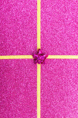 gold gift ribbon bow on purple shiny background