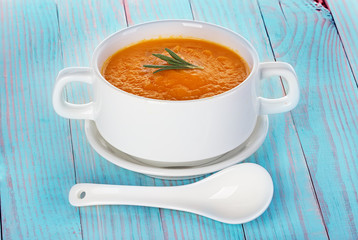 Pumpkin soup in a bowl on a wooden background