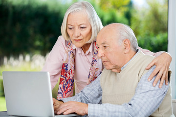 Serious Senior Man And Woman Using Laptop