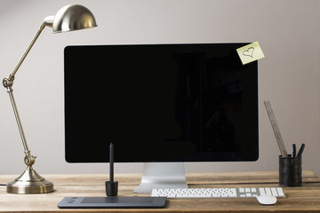 big computer screen with stationary items