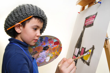artist school boy painting brush watercolors portrait on a easel