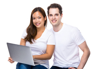Asian woman and caucasian man using notebook together