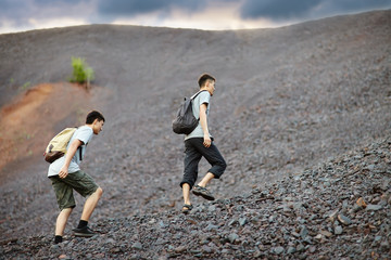 Men walks on stones slope