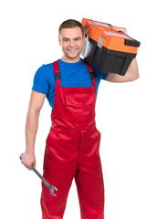 Young worker holding tool box against white.