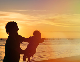 Fototapeta premium Father and little daughter silhouettes at sunset