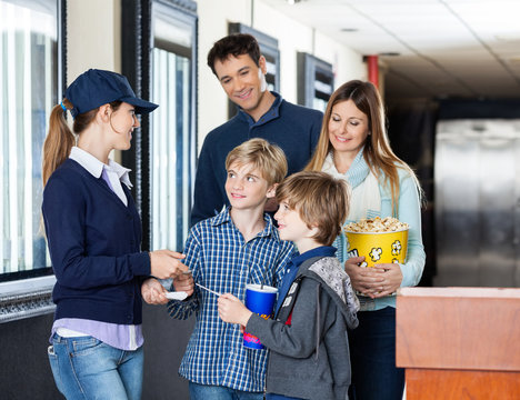 Worker Checking Tickets Of Family At Cinema